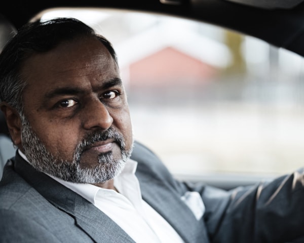 Mann i stillestående bil med telefon i hånden