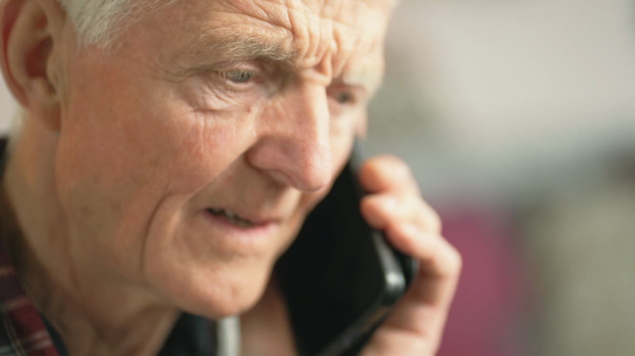 Eldre mann som snakker i mobiltelefonen sin.